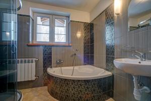 a bathroom with a bath tub and a sink at Noclegi Dwór Szlachecki Biedaczów in Biedaczów +91 photos