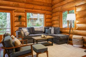 a living room with a couch and a table in a log cabin at Wilderness Retreat in Glacier