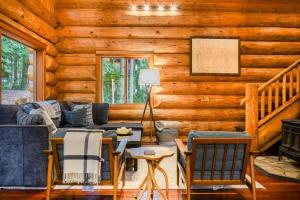 a living room with a couch and chairs in a log cabin at Wilderness Retreat in Glacier