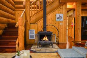 a fireplace in the middle of a room in a log cabin at Wilderness Retreat in Glacier +41 photos
