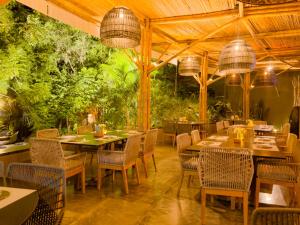 a restaurant with tables and chairs and plants at Gran Tamoanchan in General Pedro Antonio Santos