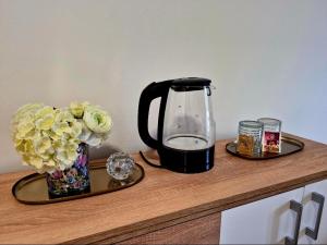 a coffee pot and vase of flowers on a counter at Station rooms Trenčín in Trenčín +8 photos