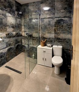 a bathroom with a toilet and a glass shower at Station rooms Trenčín in Trenčín