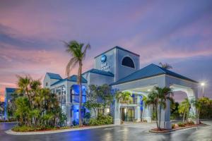 a building with palm trees in front of it at Best Western Lake Okeechobee in Okeechobee