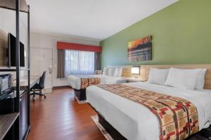 a hotel room with two beds and a flat screen tv at Best Western Lake Okeechobee in Okeechobee