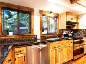 una cucina con mobili in legno e un lavello in acciaio inossidabile di Wild Goose Lodge a Glacier