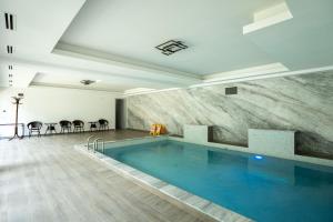 a large swimming pool in a large room with at Vila Popasul Dacilor in Grădiştea de Munte