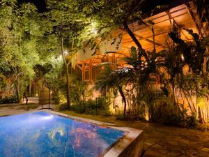 a swimming pool in front of a building with trees at Gran Tamoanchan in General Pedro Antonio Santos