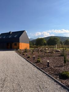 a barn with a gravel road in front of it at 4Sosny, jacuzzi, siłownia, sauna, widok na Śnieżkę in Miłków