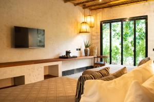a living room with a couch and a tv in a room at Gran Tamoanchan in General Pedro Antonio Santos