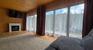 a living room with a couch and a large window at Forest House in Yablunytsya