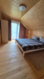 a bedroom with a bed in a wooden room at Forest House in Yablunytsya
