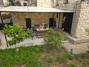 an outdoor patio with a table and chairs at Eagles Nest Guesthouse- Garden Lily House in Batroûn
