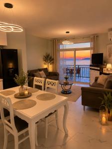a living room with a table and chairs and a view of the ocean at Avela Beach Apartments in Durrës