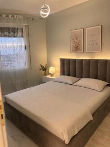 a bedroom with a large bed and a window at Avela Beach Apartments in Durrës +25 photos