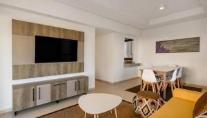 a living room with a flat screen tv and a table at Radisson blu résidence alhcoeima in Al Hoceïma +4 photos