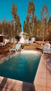 a swimming pool with two lawn chairs and two chairs at Apartamento Cerrito in San Rafael