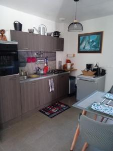 a kitchen with wooden cabinets and a table with a tableablish at Chambre Ploeren in Ploeren