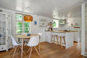 a kitchen with a table and chairs in a room at 1195-Ringkobing-Risbjergvej-84 in Ringkøbing