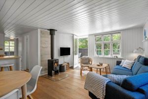 a living room with a blue couch and a stove at 1195-Ringkobing-Risbjergvej-84 in Ringkøbing
