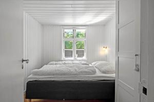 a bed in a white room with a window at 1195-Ringkobing-Risbjergvej-84 in Ringkøbing