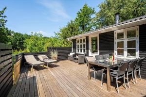 a deck with a table and chairs on a house at 1195-Ringkobing-Risbjergvej-84 in Ringkøbing