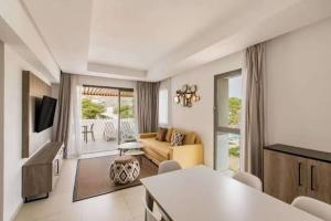 a living room with a couch and a television at Radisson blu résidence alhcoeima in Al Hoceïma