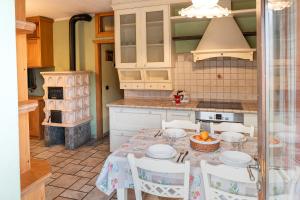 a kitchen with a table with chairs and a stove at Appartamento TreZero in Valfurva