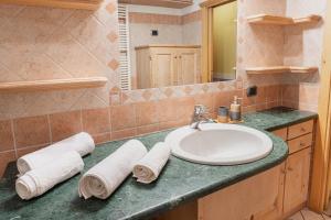 a bathroom with a sink and a mirror and towels at Appartamento TreZero in Valfurva