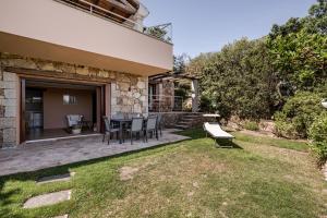 a patio with a table and chairs in a yard at BeLocations - Aldia Garden Seaview in Puntaldia