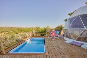 a tent and a swimming pool on a wooden deck at Geo heaven glamp in Aïtánia