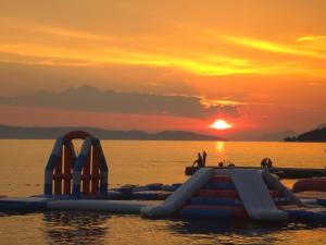 a group of inflatable slides in the water at sunset at Apartmani Ante 1 in Drašnice +1 photo