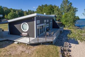 a tiny house with a large deck on the beach at VGO1063-Karlsborg-Silverdalen-1 in Karlsborg