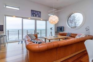 a living room with a brown leather couch and a table at VGO1063-Karlsborg-Silverdalen-1 in Karlsborg