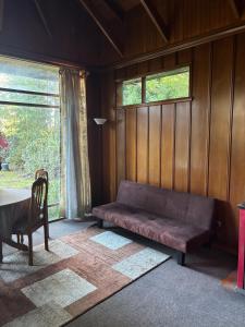 a couch in a room with a table and a window at cabañas kiel in Llanquihue