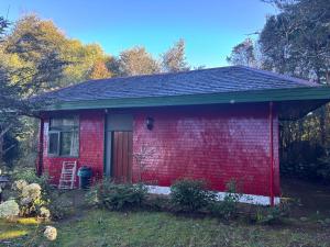 a small red brick house with a door at cabañas kiel in Llanquihue