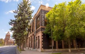 a building with a sign on the side of a street at Cathedral Plaza Hotel in Gyumri