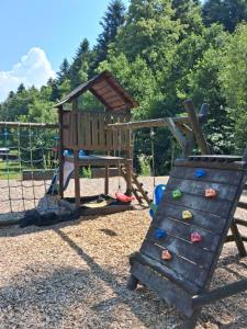 a playground with a slide and a play structure at Srub v lese in Hrabŭvka