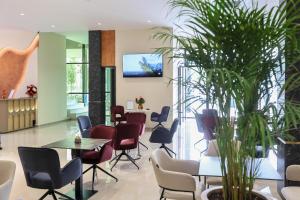 a waiting room with chairs and tables and a tv on the wall at Best Western Plus The Met Tirana Hotel in Tirana