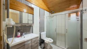 a bathroom with a shower and a toilet and a sink at Villa Efsane Hotel in Cıralı +62 photos