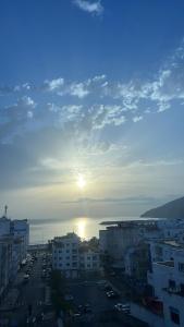a view of a city with the sun setting over the water at Mdiaq in M'diq