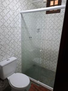 a bathroom with a toilet and a glass shower at Encanto na Mata in Mata de Sao Joao +15 photos
