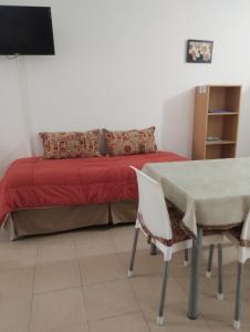 a bedroom with a bed and a table and chairs at Montalto II in Dina Huapi