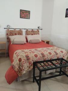 a bedroom with a bed with a red comforter at Montalto II in Dina Huapi