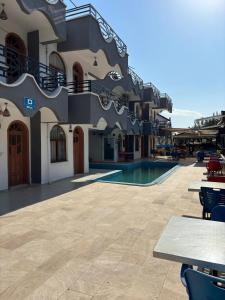a building with a swimming pool and tables and chairs at Sincer Otel in Kuşadası