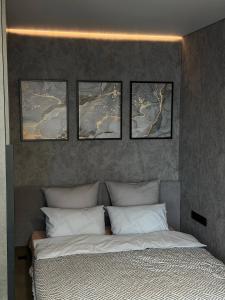 a bedroom with four pictures above a bed at Studio Loft in Fontanka