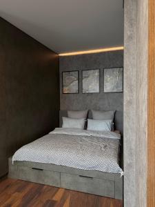 a bedroom with a bed with three pictures on the wall at Studio Loft in Fontanka