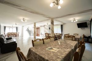 a room with a table and chairs and a television at Vila Popasul Dacilor in Grădiştea de Munte