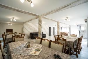 a restaurant with tables and chairs in a room at Vila Popasul Dacilor in Grădiştea de Munte