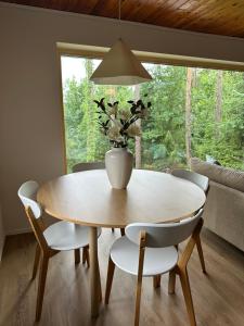 a dining room table with chairs and a vase with flowers at Mezi Smrky in Bohostice